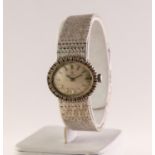 LADY'S 18ct WHITE GOLD WRISTWATCH, with mechanical movement, oval silvered dial with batons, the