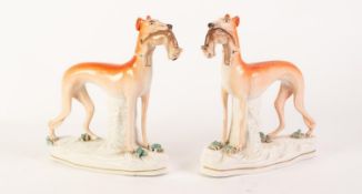PAIR OF NINETEENTH CENTURY STAFFORDSHIRE POTTERY MODELS OF GREYHOUNDS, each modelled standing with a