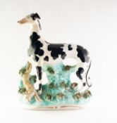 NINETEENTH CENTURY STAFFORDSHIRE POTTERY LARGE MODEL OF A PIEBALD GREYHOUND, painted in colours
