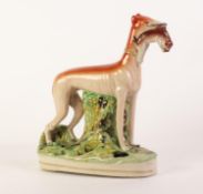 NINETEENTH CENTURY STAFFORDSHIRE POTTERY LARGE MODEL OF A GREYHOUND, painted in colours and