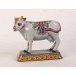 PROBABLY 19th CENTURY DUTCH POLYCHROME DELFT MODEL OF A COW standing on a canted oblong spreading