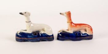 TWO NINETEENTH CENTURY STAFFORDSHIRE POTTERY GREYHOUND PEN HOLDERS, typically modelled, one white,