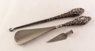 SHOEHORN AND A BUTTON HOOK, each with an Edwardian silver handle repousse with rococo scrolls,