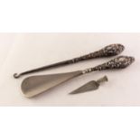 SHOEHORN AND A BUTTON HOOK, each with an Edwardian silver handle repousse with rococo scrolls,