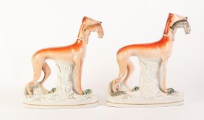 MATCHING PAIR OF NINETEENTH CENTURY STAFFORDSHIRE POTTERY LARGE MODELS OF GREYHOUNDS, each painted