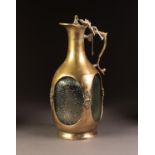 HEAVY BRASS MOUNTED AND ENCASED MOULDED GLASS CLARET JUG, of square form with scroll handle and