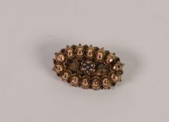 VICTORIAN GOLD COLOURED METAL OVAL BROOCH, the centre set with a daisy cluster of seven seed pearls,