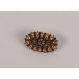 VICTORIAN GOLD COLOURED METAL OVAL BROOCH, the centre set with a daisy cluster of seven seed pearls,