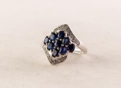 9ct WHITE GOLD, SAPPHIRE AND WHITE STONE CROSSOVER RING, with a diamond shaped setting of nine