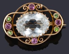 A delicate Edwardian pink and green gem stone set scroll brooch