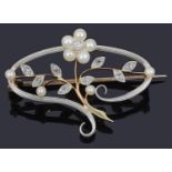 A delicate Edwardian diamond and pearl set floral scroll brooch