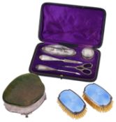 A George V silver jewellery box; a silver manicure set; one other