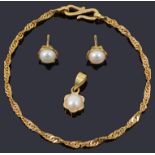 A pair of gold cultured pearl earrings and matching pendant on a gold chain