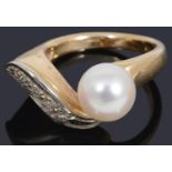 A gold single stone pearl and diamond crossover ring