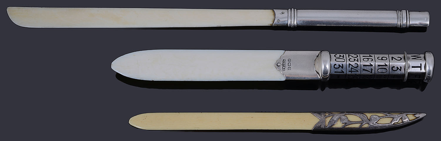 A George V silver and ivory perpetual calendar paper knife; others