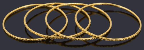 Four decorative 22ct gold bangles