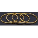 Four decorative 22ct gold bangles