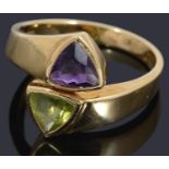 A gold peridot and amethyst cross over ring