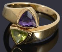 A gold peridot and amethyst cross over ring