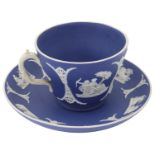 A 19th century Wedgwood tea cup and saucer in white on dark blue dipped jasperware