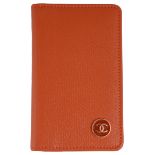 A classic Chanel card holder in caviar orange leather