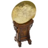 An early Chinese polished metal hand mirror on a carved hardwood stand