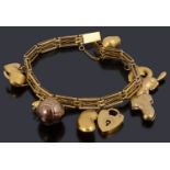 A 9ct gold three row charm bracelet with padlock and nine assorted charm and another loose charm