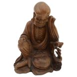 A late 19th/early 20th century Chinese hardwood carving of a seated Luohan