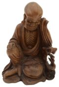 A late 19th/early 20th century Chinese hardwood carving of a seated Luohan