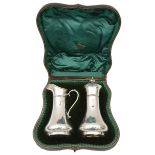 An Edward VII cased silver sugar caster and matching cream jug