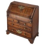 A 19th century George II style miniature walnut and oak bureau