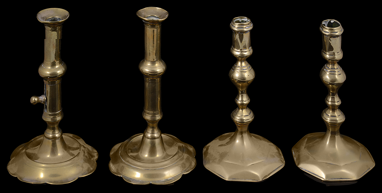 Two pairs of George I and II brass candlesticks