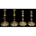 Two pairs of George I and II brass candlesticks
