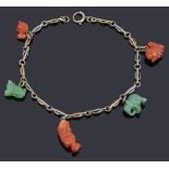 A two colour gold fancy link charm chain with assorted green hard stone and coral charms