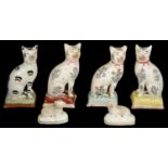 Four early 19th Century Staffordshire pottery cats and a pair of small recumbent sheep