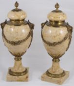 A pair of late 19th century French Louis XVI style ormolu mounted marble urns and covers