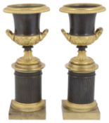 A pair of early 19th century French Empire style bronze and ormolu mounted campana urns c.1830