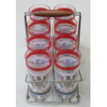 1950s STYLE STAND CONTAINING SET OF EIGHT DRINKING GLASSES,