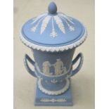 WEDGWOOD BLUE JASPERWARE TWO HANDLED URN AND COVER ON STEMMED SUPPORTS,
