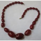 STRAND OF GRADUATED CHERRY AMBER BEADS