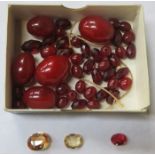 SMALL PARCEL OF LOOSE CHERRY AMBER BEADS AND THREE LOOSE SEMI-PRECIOUS STONES