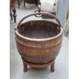 CAST IRON BOUND BARREL FORM CARRIER WITH HANDLE ON RAISED STAND,