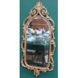 20th CENTURY PIERCEWORK GILT METAL AND BEVELLED WALL MIRROR,