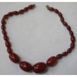 STRAND OF GRADUATED CHERRY AMBER BEADS