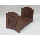 SMALL OAK BOOK STAND WITH CARVED DECORATION TO EITHER END