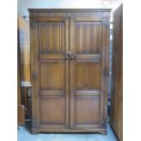 20th CENTURY OAK LINEN FOLD FRONTED TWO DOOR WARDROBE