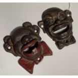 Pair of character cast iron masks (Bottles Openers) and a pair of cast brass candle sticks
