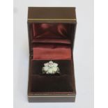 Cased 18ct white gold floral dress ring set with opals & clear stones.