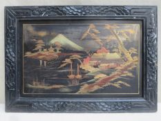 Japanese ebonised panel within frame, decorated with a gilded scene depicting boats on a lake beside
