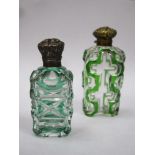 Two victorian green overlay cut glass scent / perfume bottles, both with ornately decorated hinged
